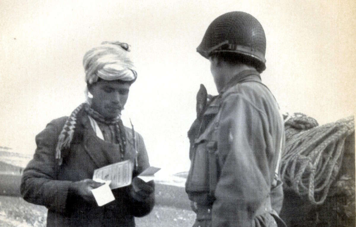 Un paysan dans les monts Fou toub est contrôlé par un soldat français en 1954.