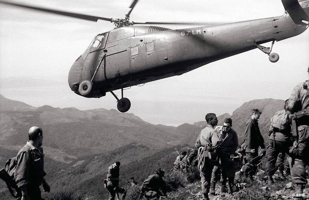 Un hélicoptère Sikorsky H-34 survole des soldats de l’armée de l’air,