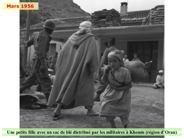 Mars 1956 Une petite fille avec un sac de blé distribué par les militaires à Khemis (région d’Oran)