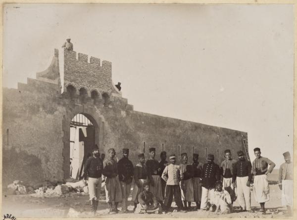 Colonne du capitaine Pujat chargé de la construction du Fort Lallemand : groupe d'officiers et de soldats posant après l'achèvement de la porte, dont probablement le capitaine Pujat au centre] (Photo rare)