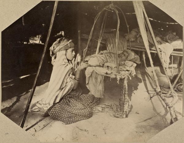 [Campement dans la région de Biskra : fillette surveillant un nourrisson] (Photo rare)