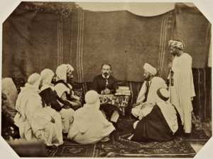 Bureau arabe départemental de Mostaganem. Ben Tillis, mokkadem des Beni Mzab, Mohammed Ben Djeriou, cheik de Mazagran, Si Abd-El-Kader, cheik de la vallée, le capitaine Gasselin, chef du service indigène, Bel Gassem Ben Kritli, amin des Berrani-Ouada, Chaouch, deux plaignants. (Image de propagande coloniale)