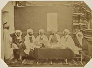 Midjelès d'Oran. [de gauche à droite] Si Mohammed ben El Hadj Hassen, amin des Berrani, Si Abd-El-Kader El Fetouhi, adel, Si Adda ben Arriba, cadhi des douars, Si Mohammed Bel Gaïd, cadhi d'Oran, Si Hamida ben El Caid Omar, muphti d'Oran, président, Si Mohammed Bel Alia, cadhi des Gharraba, Si El Hadj Mohammed ben Mustapha, bach-adel (Image de propagande coloniale)