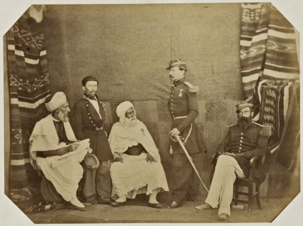 Bureau arabe d'Oran. [de gauche à droite] Si Mohammed ben Ahmed Khodja du bureau, M. Pobeau interprète titulaire de 2ème classe à la direction, El Hadj Mazary, ancien agha du Makhzen d'Oran, Commandant Chanzy, commandant divisionnaire des affaires arabes de la Province d'Oran, le capitaine Loliot, détaché à la direction des affaires arabes. (Image de propagande coloniale)