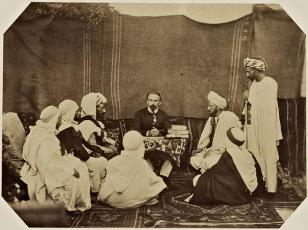 Bureau arabe départemental de Mostaganem. Ben Tillis, mokkadem des Beni Mzab, Mohammed Ben Djeriou, cheik de Mazagran, Si Abd-El-Kader, cheik de la vallée, le capitaine Gasselin, chef du service indigène, Bel Gassem Ben Kritli, amin des Berrani-Ouada, Chaouch, deux plaignants. (Image de propagande coloniale)