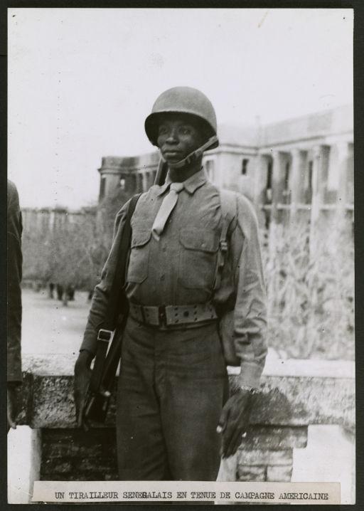 Alger - Avril 1944 - Entrainement des troupes coloniales à Alger dans un régiment de tirailleurs sénégalais - Un tirailleur en tenue de campagne américaine (Image de propagande coloniale)