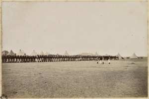 [Campement de la colonne du capitaine Pujat chargé de la construction du Fort Lallemand : passage en revue des troupes de la colonne] (Image de propagande coloniale)