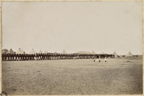 [Campement de la colonne du capitaine Pujat chargé de la construction du Fort Lallemand : passage en revue des troupes de la colonne] (Image de propagande coloniale)