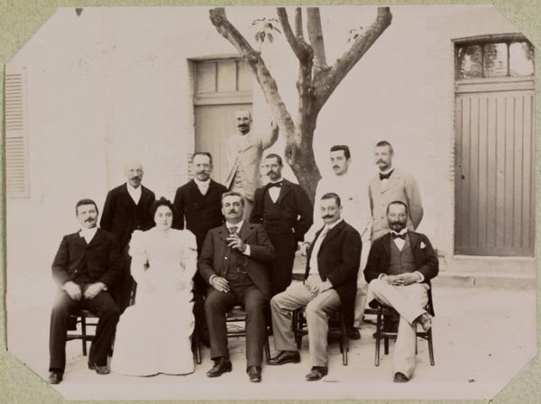 M. Etienne à Ammi-Moussa. M. Vermot, greffier notaire (contre l'arbre), (de gauche à droite au 1er rang) M. Bucher, adjoint à l'administrateur, Lilotte, administrateur, Vauthier, 2ème adjoint, Chassain secrétaire de la commune mixte, 2ème rang assis, Loizon, receveur particulier, Mme Lilotte, M. Etienne, député, M. Ramier, conseiller général, M. Prades' (Image de propagande coloniale)