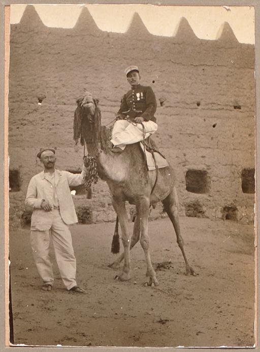 [Légende au dos du cliché :] Moi [capitaine Germain], Gugusse et le postier d'In-Salah [Signé 