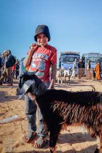 Petit garnement promenant sa chèvre : complicité espiègle