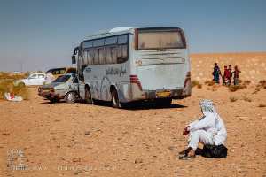 Homme assis sur son cabas : la patience au soleil