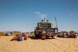 Homme et Land Rover : repos dans l’immensité du désert