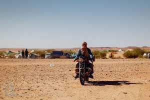 Homme à moto, chèche au vent : l’esprit du désert en mouvement