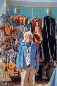 Vieux commerçant vendant des vestes et manteaux : la tradition au service du confort