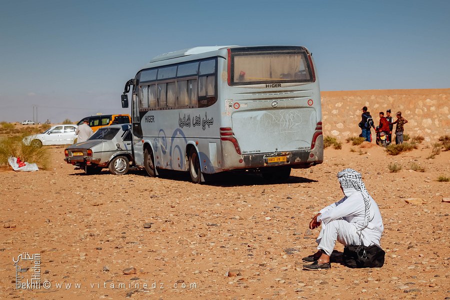 Homme assis sur son cabas : la patience au soleil