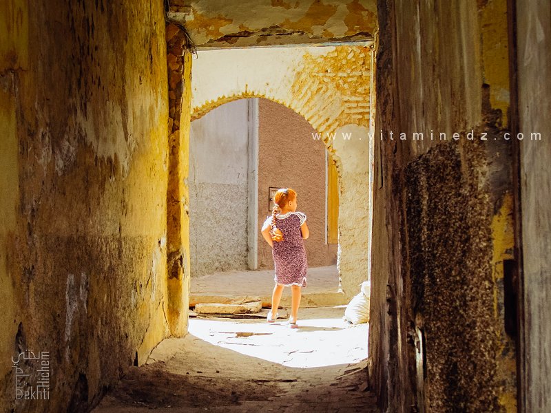 Petite fille traversant une ancienne porte en arc (Derb Beni Djemla, Médina de Tlemcen)