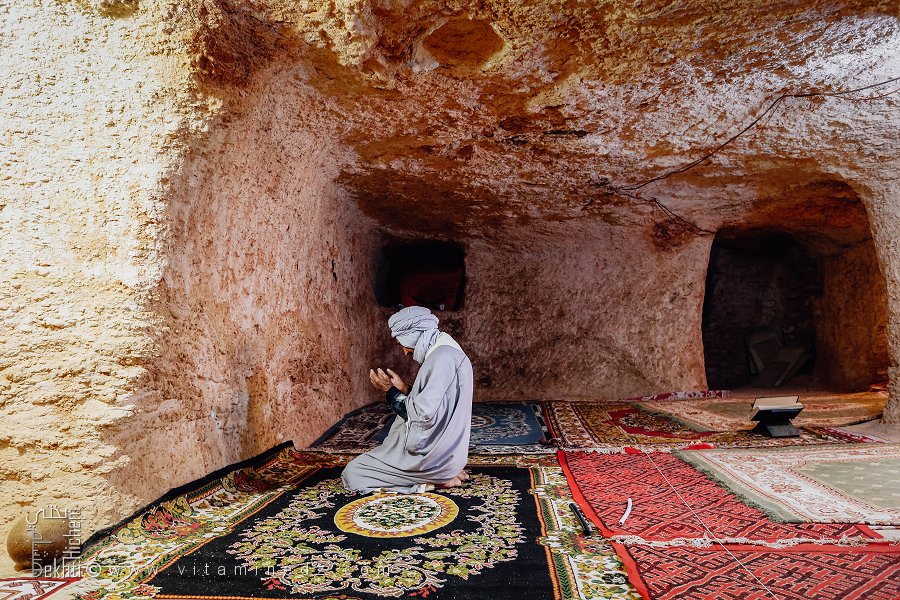 Vieil homme pieux en prière dans la mosquée souterraine – Zaouia Mouahdine (Commune de Rogassa, Wilaya d'El Bayadh)