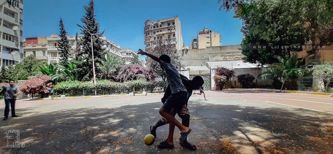 Enfants jouant au foot dans la cour du jardin Khemisti, Oran