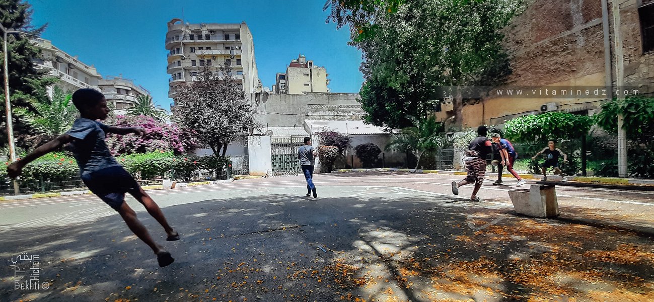 أطفال يلعبون كرة القدم في ساحة حديقة خميستي، وهران