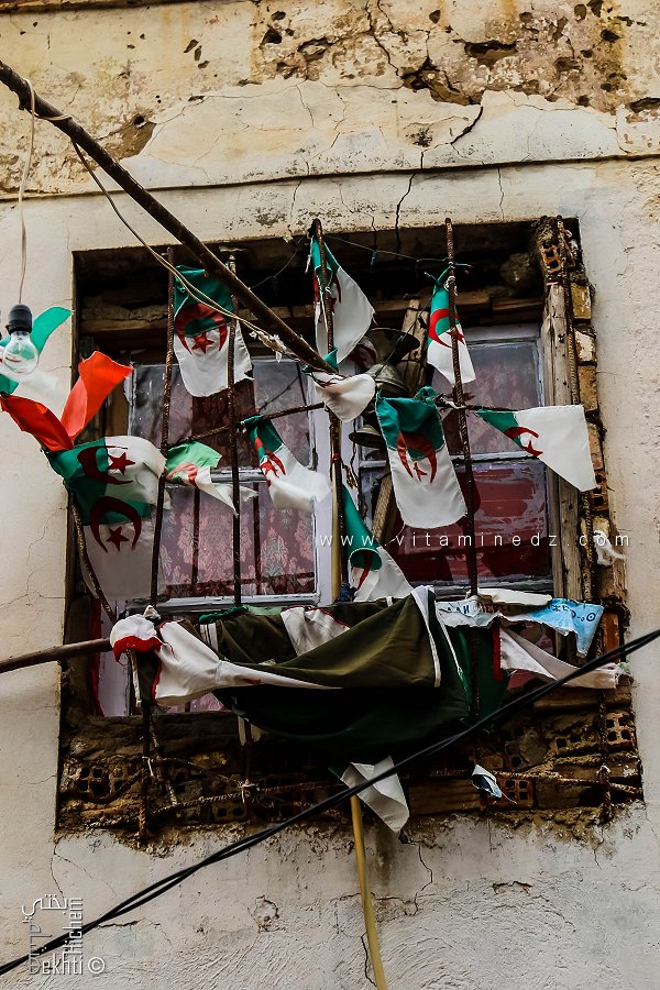 Drapeaux algériens à une fenêtre d'une habitation de Hammam Sidi Abdelli (Commune de Sidi Abdelli, Wilaya de Tlemcen)
