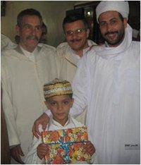 صورة إمام مسجد مالك بن نبي بأفلو.وعلى اليسار رئيس البلدية.وسطهم الطفل محمد شاشي إسلام .تكريمه لمواصلة حفضه القرأن الكريم