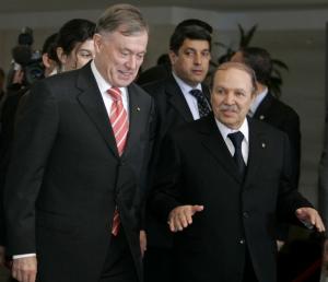 Algeria's President Abdelaziz Bouteflika (R) walks next to his