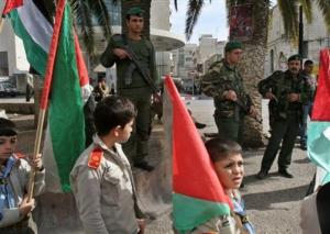 Palestinian police stand guard as children participate in a