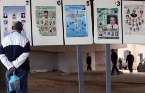 An Algerian looks at municipal electoral posters in Algiers