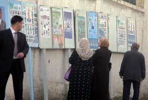 Algerians look at municipal electoral posters in Bologhine district
