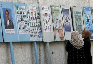 Algerian women look at municipal electoral posters in Bologhine