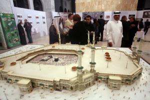 Algerians and Saudis stand next a huge model of