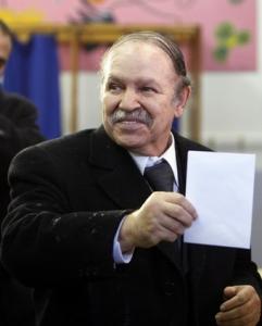 Algeria's President Abdelaziz Bouteflika holds a ballot paper for