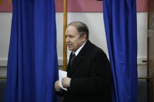 Algeria's President Abdelaziz Bouteflika holds a ballot paper for