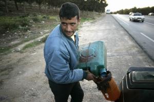 A man sells illegal petrol at a road near