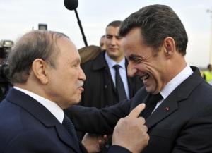 France's President Nicolas Sarkozy (R) is greeted by Algeria's