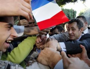 French President Nicolas Sarkozy shakes hands with supporters, as