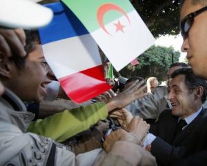France's President Nicolas Sarkozy shakes hands with supporters as
