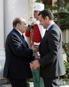 France's President Nicolas Sarkozy (R) is greeted by Algeria's