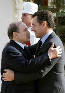 France's President Nicolas Sarkozy (R) is greeted by Algeria's