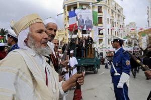 Algerians (L) in traditional garb walk during a visit