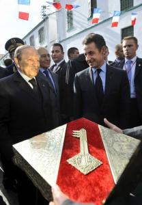 Algerian President Abdelaziz Bouteflika (L) presents the key of