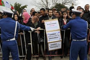 Algerian police hold mobile barriers retaining the crowd as
