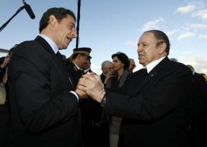 France's President Nicolas Sarkozy (L) shakes hands with his