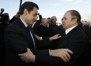 France's President Nicolas Sarkozy (L) hugs his Algerian counterpart