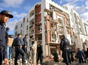 Rescuers and policemen work near a destroyed building at