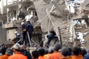 Rescuers work through the rubble of a destroyed building