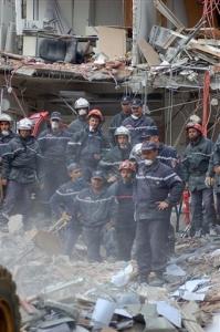 Rescue workers stand by as a bulldozer clears the