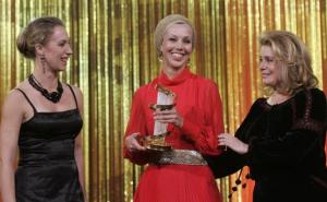 French actress Catherine Deneuve (R) smiles after presenting the