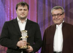 Russian film director Alexei Mizgirev (L) holds the golden